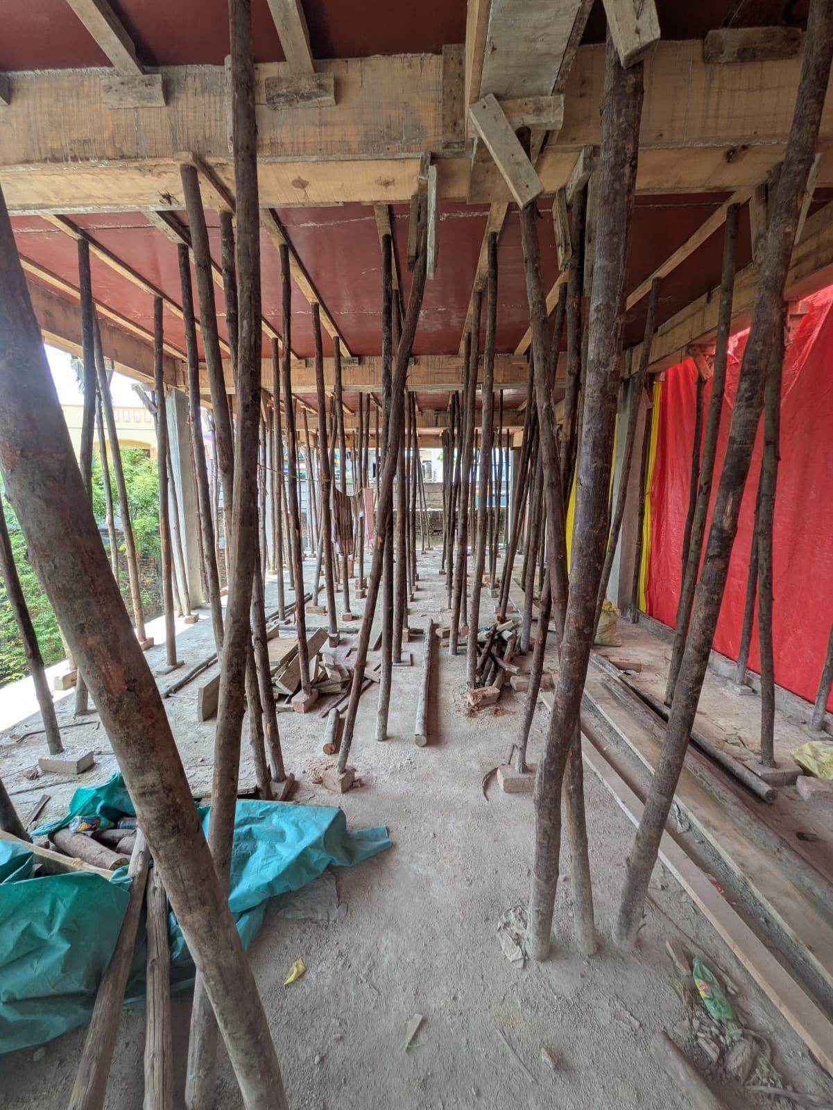 Wooden pole and plank shuttering formwork supporting a cast slab