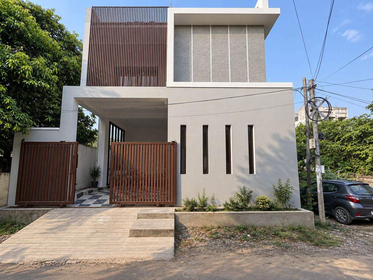 Completed two-storey villa exterior with stone cladding and wooden louvres